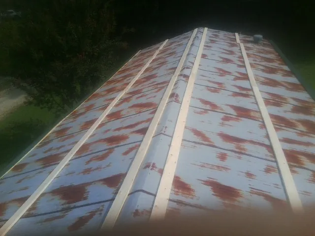 Rusted metal roof panels with new wood purlins before replacement — Storm Damage Roof Repair in Lenox by Roofing Brothers